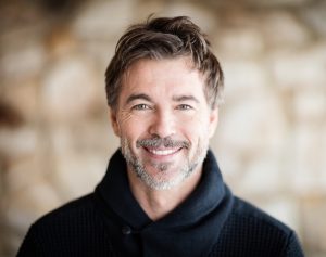 A man smiling with healthy teeth because he got regular dental check-ups.